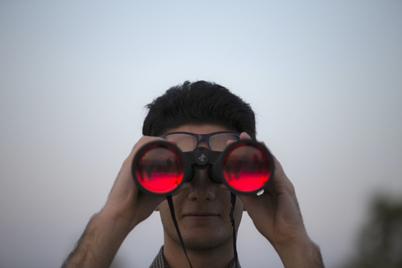 Man with binoculars searching for the right job; looking for a job that will make you happy